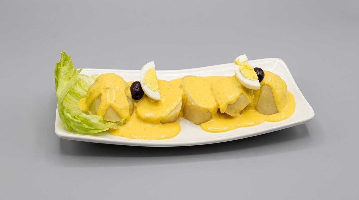 Papa a la Huancaina — potatoes in creamy huancaina sauce with egg and olives